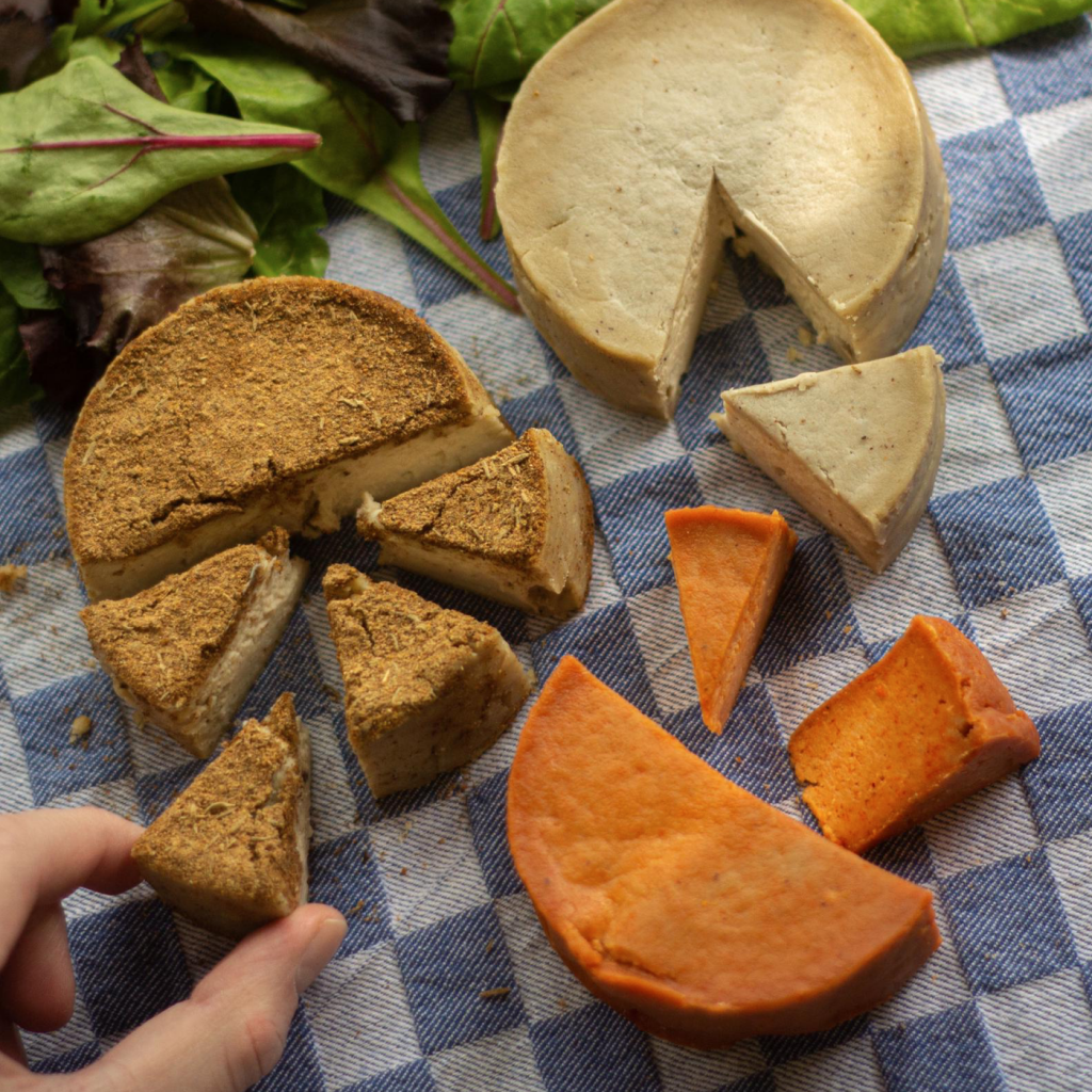 A trio of vegan cheases on a picnic blanket